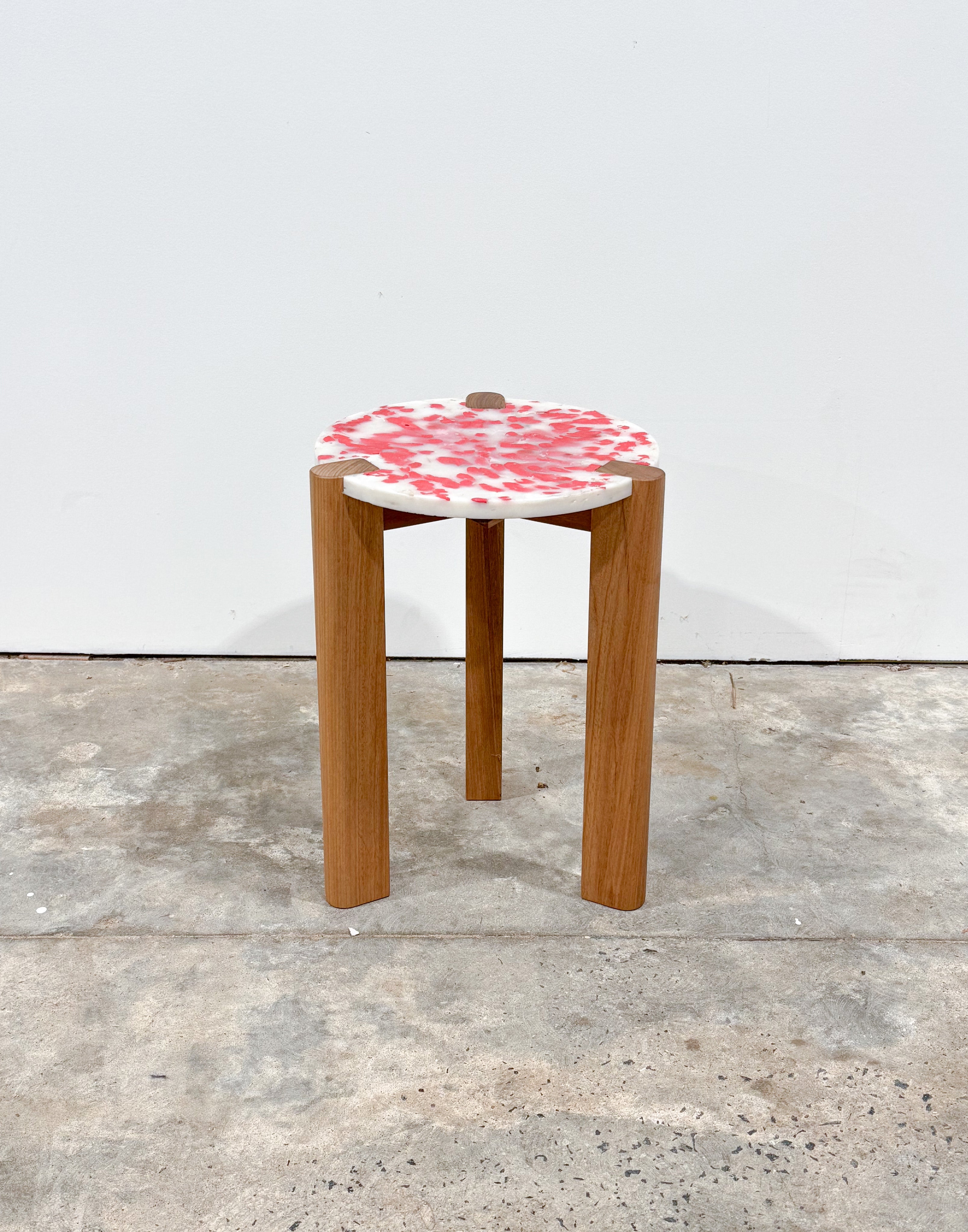 Short stool with 3 Tasmanian Oak timber legs and a red and white seat made from recycled soy sauce fish and milk bottles