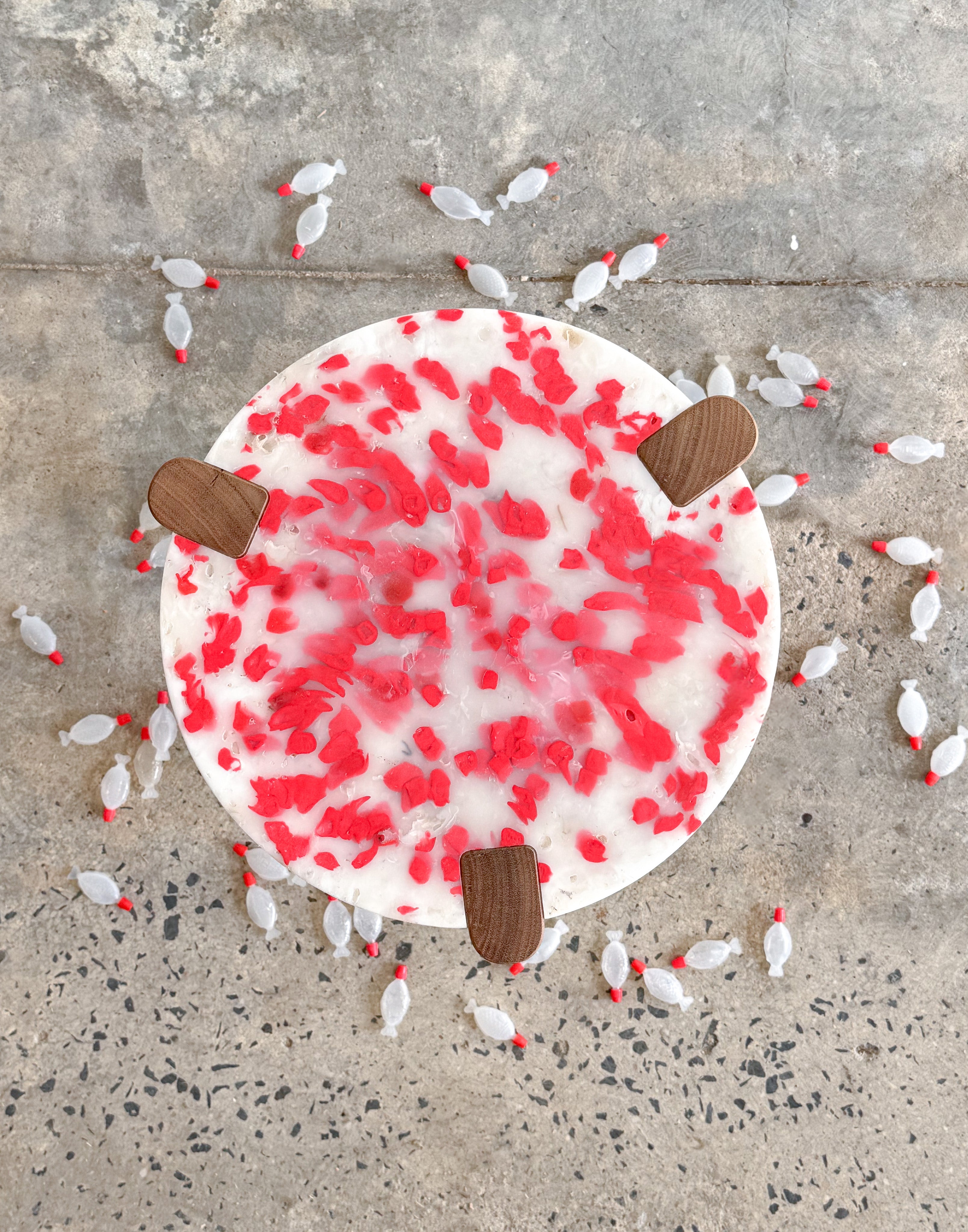 Short stool with 3 Tasmanian Oak timber legs and a red and white seat made from recycled soy sauce fish and milk bottles