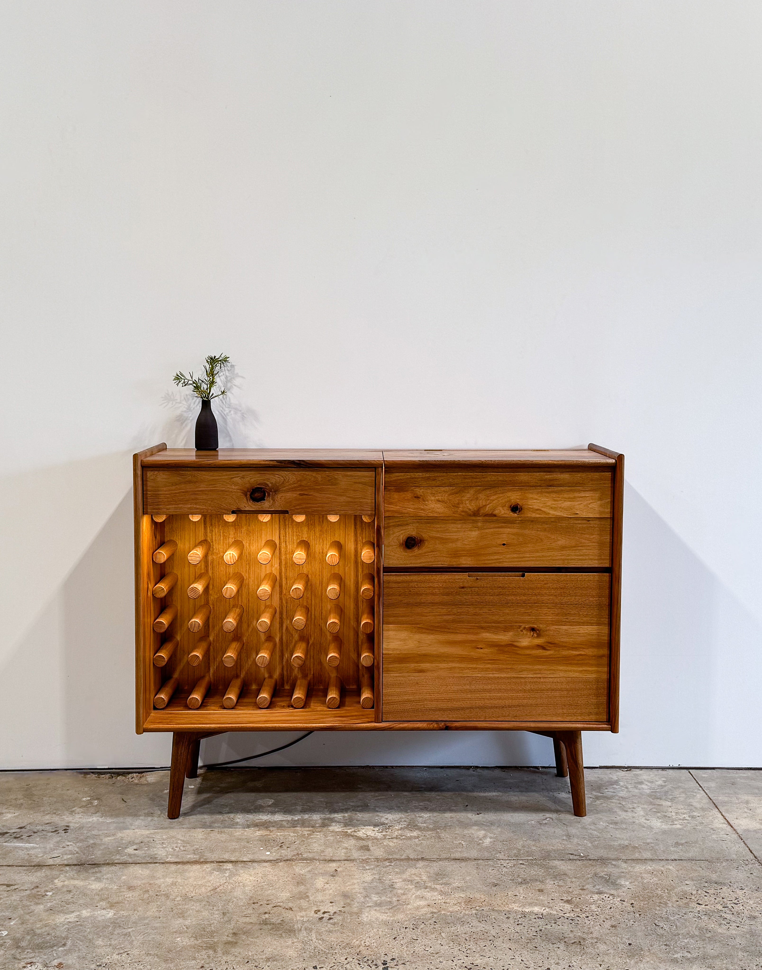 Dark brown timber drinks cabinet with wine rack, LED lighting, and mirror inlay cocktail hatch and drawer. Handmade in Melbourne Australia from Tasmanian Blackwood