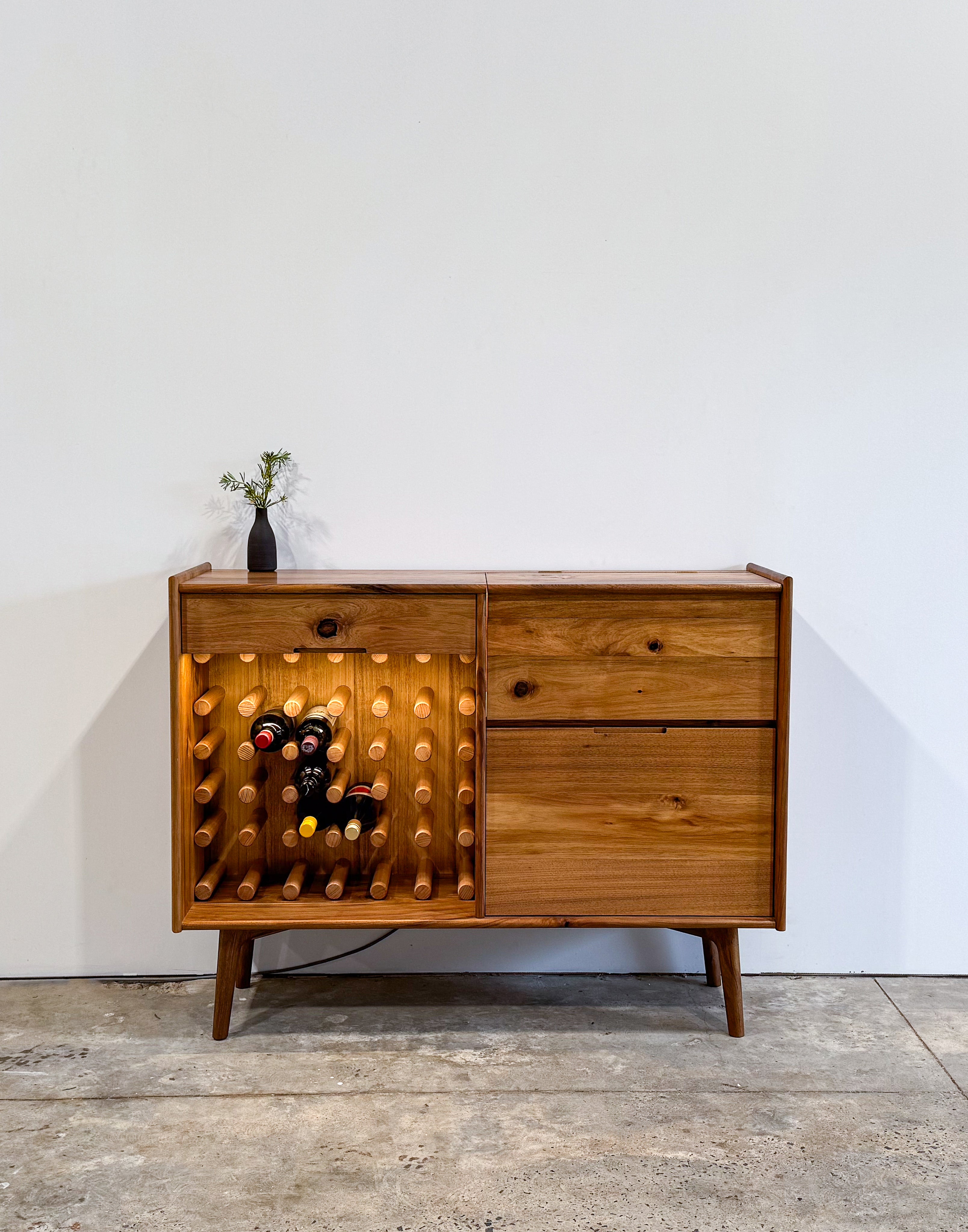 Dark brown timber drinks cabinet with wine rack, LED lighting, and mirror inlay cocktail hatch and drawer. Handmade in Melbourne Australia from Tasmanian Blackwood