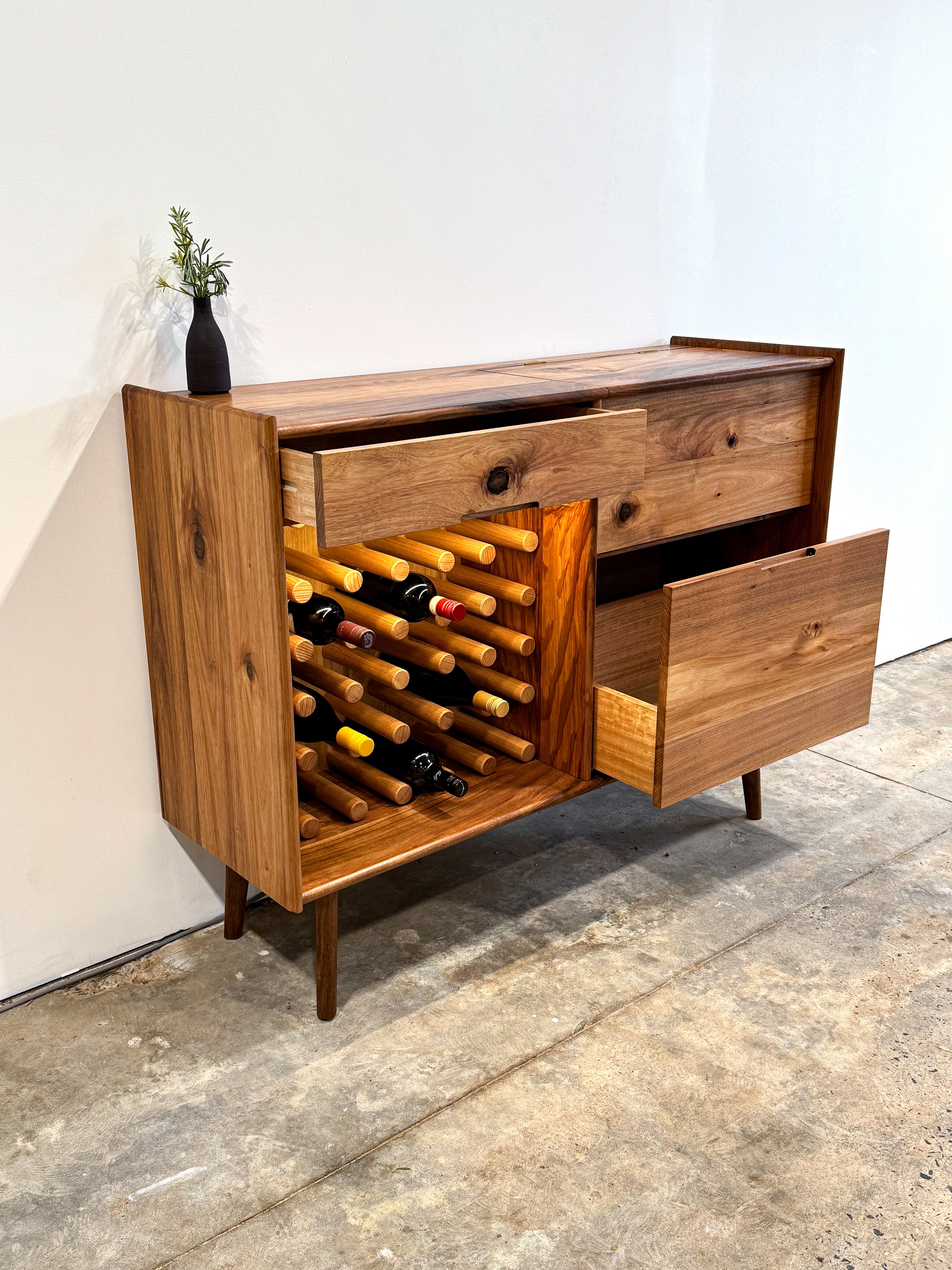 Dark brown timber drinks cabinet with wine rack, LED lighting, and mirror inlay cocktail hatch and drawer. Handmade in Melbourne Australia from Tasmanian Blackwood