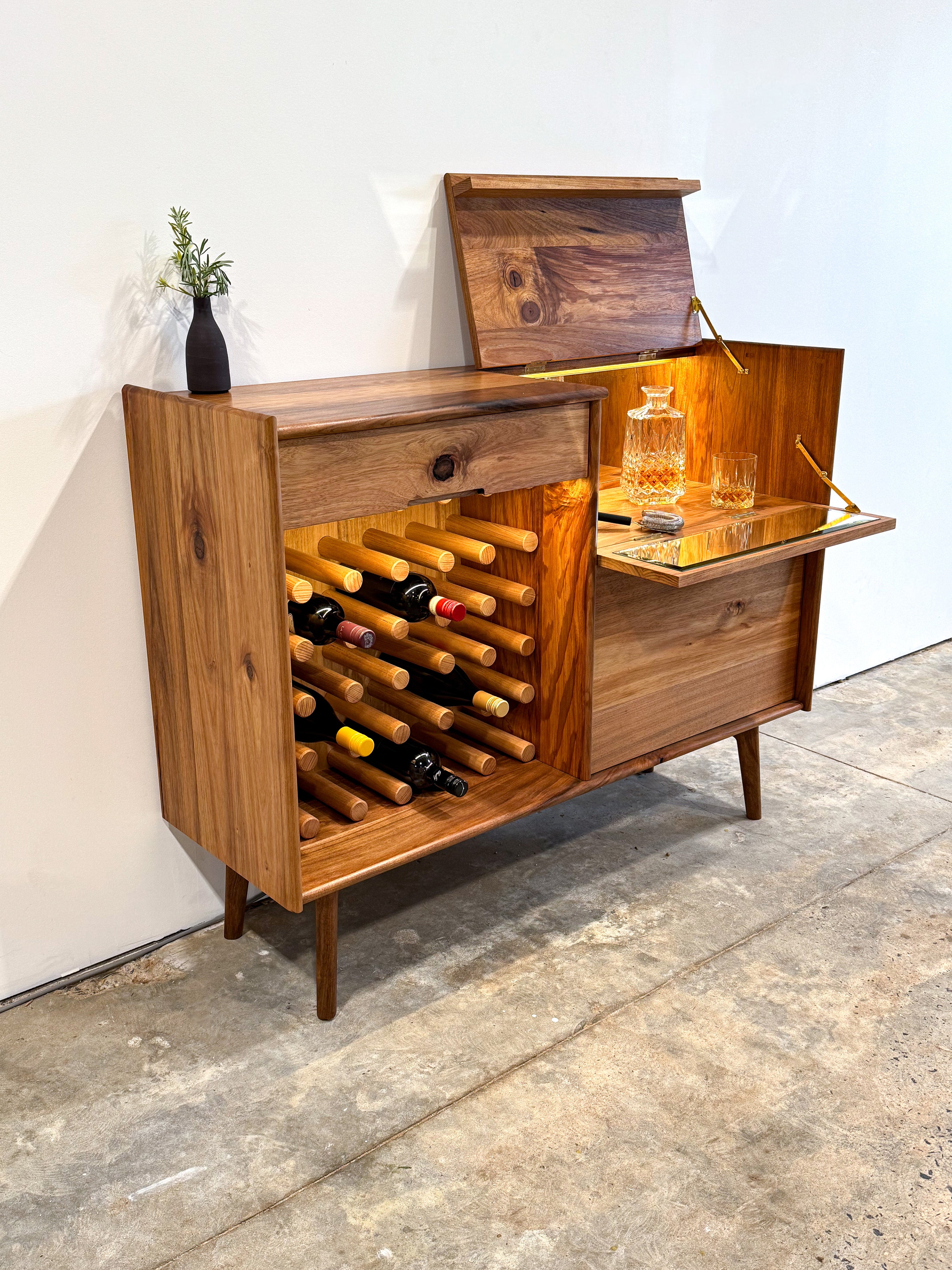 Dark brown timber drinks cabinet with wine rack, LED lighting, and mirror inlay cocktail hatch and drawer. Handmade in Melbourne Australia from Tasmanian Blackwood