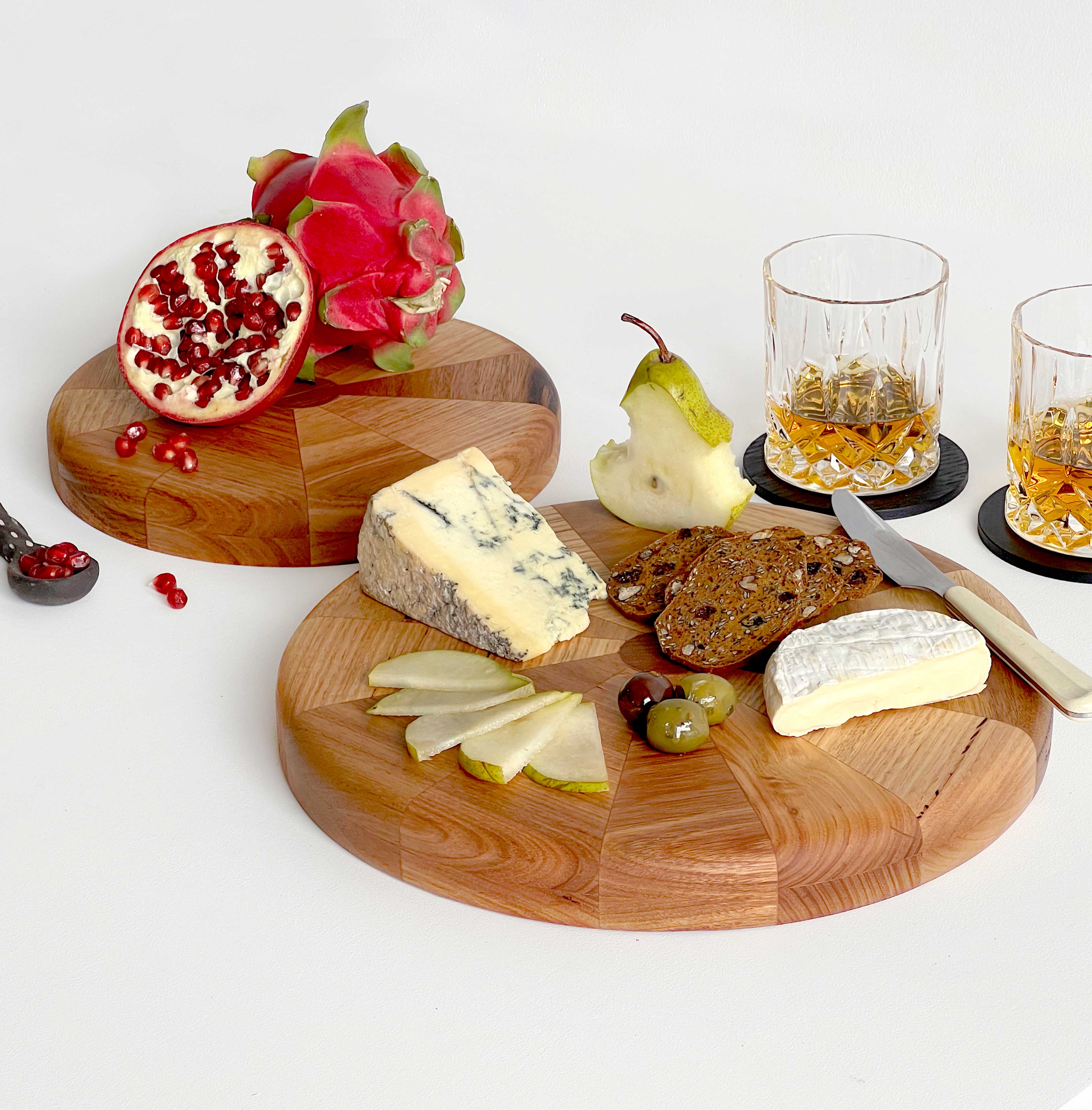 Circular Off-chops serving board displayed with fruit, cheese and glasses of whiskey