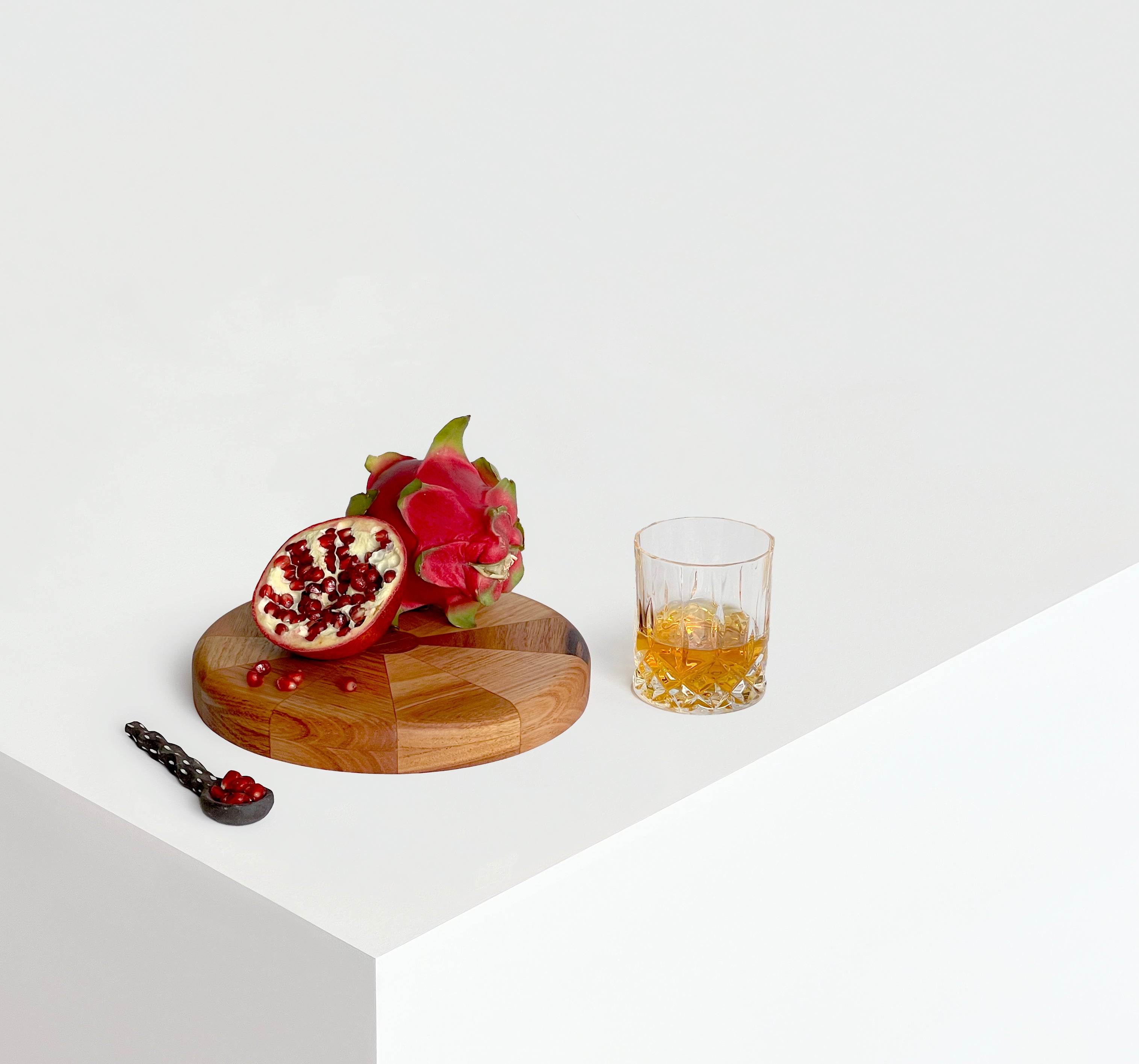 Circular Off-chops serving board displayed with fruit, cheese and glass of whiskey