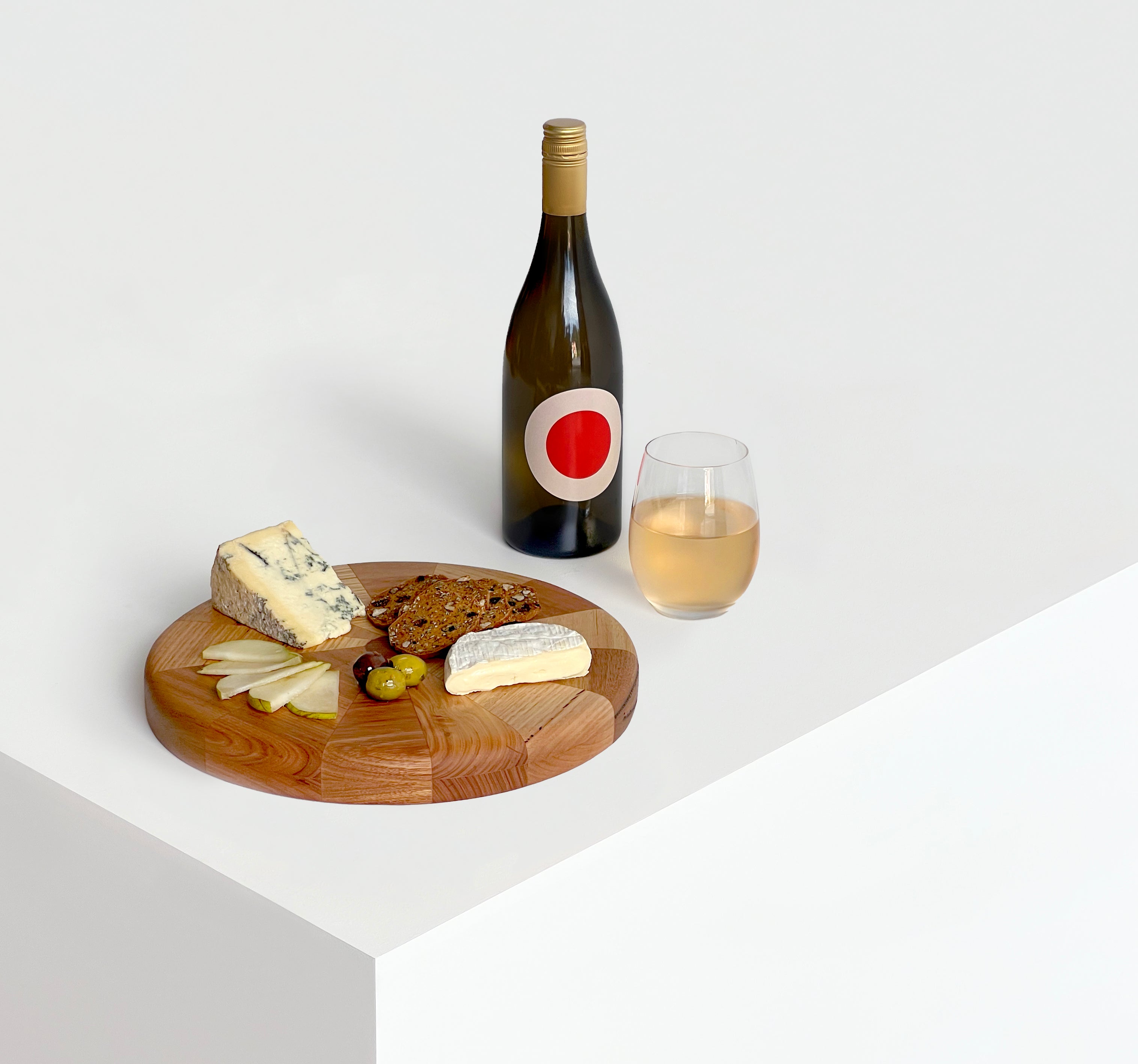 Circular Off-chops serving board displayed with fruit, cheese and wine